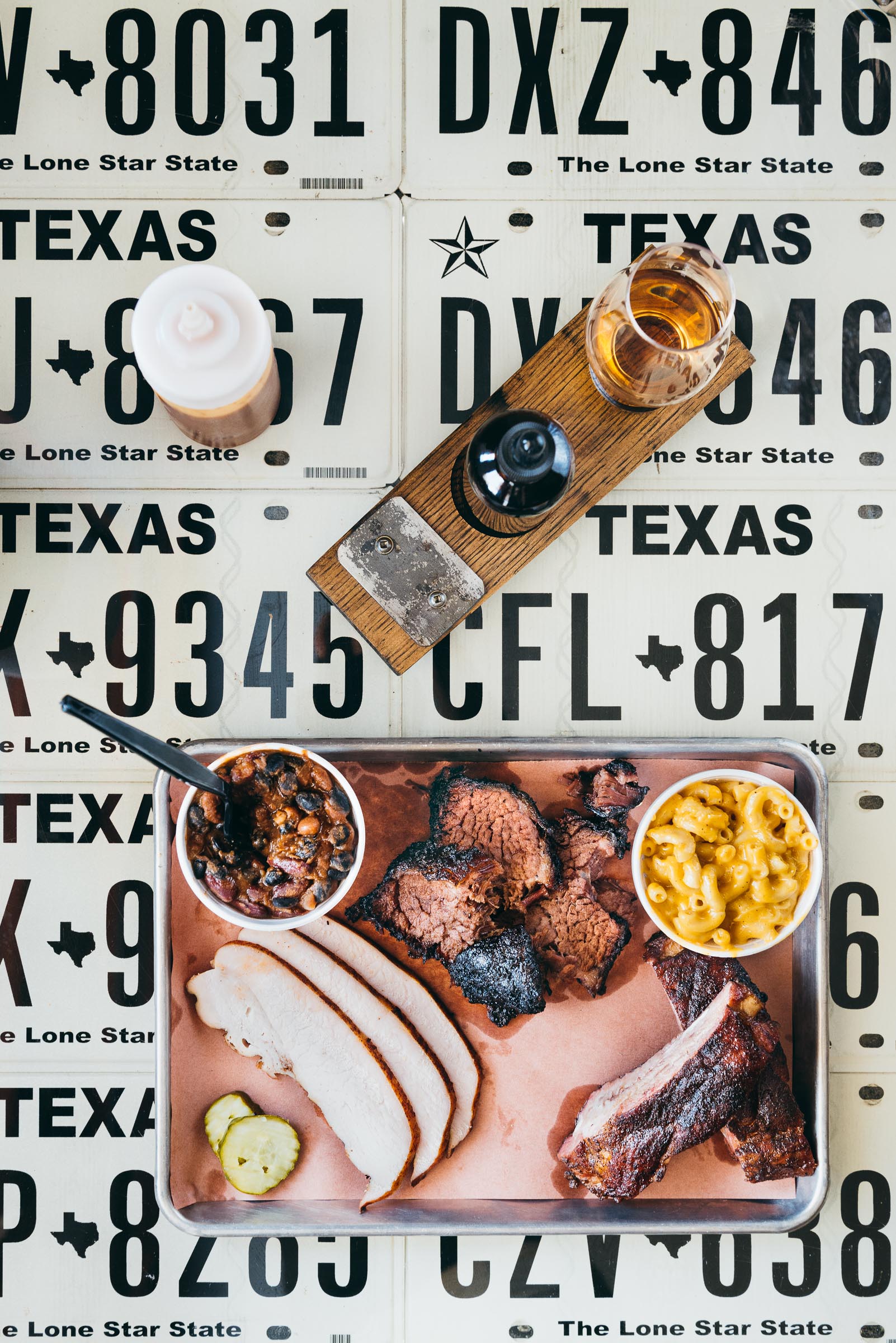 Barbecue, plated on a table made up of Texas license plates. All-The-Kings-Men-Bryan-Texas