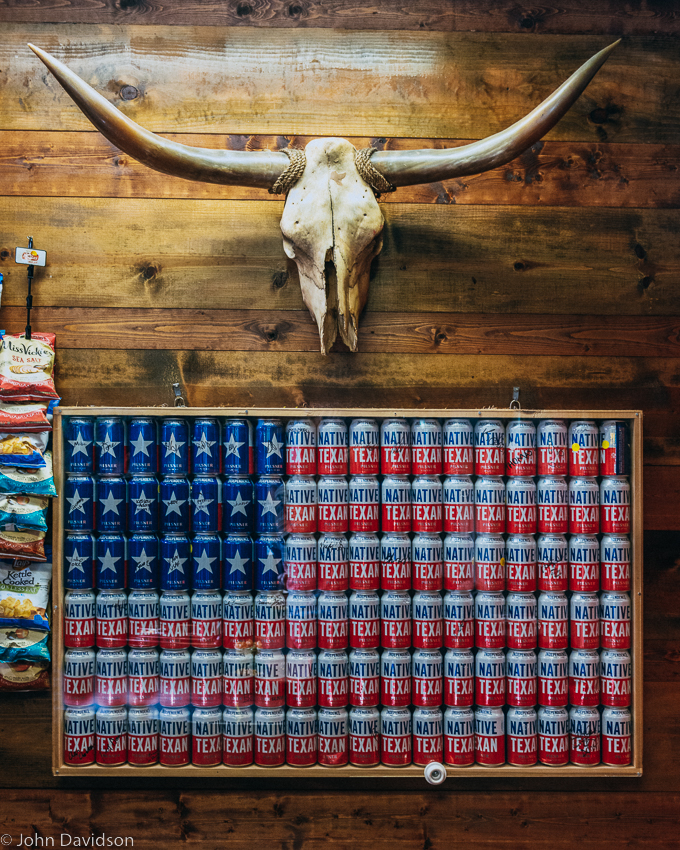 Beer cans arranged in a frame  to make a US flag  beneath a Longhorn skull -Austin-TX