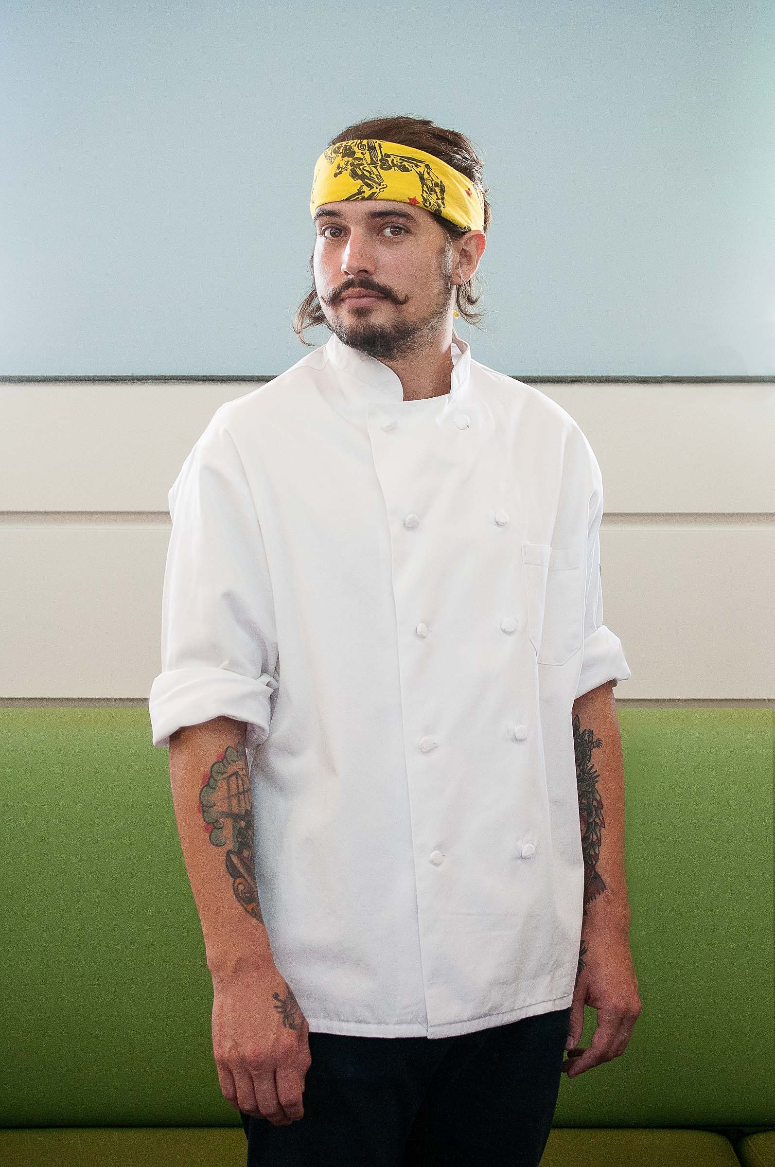 Chef Mark Ball photographed in natural light against green blue backdrop.