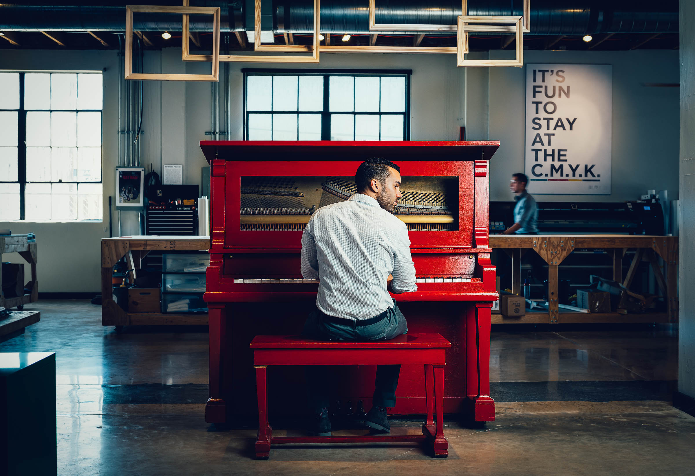 Professional business lifestyle image - Alex Hilmy plays a bright red piano in the centre of his office. 