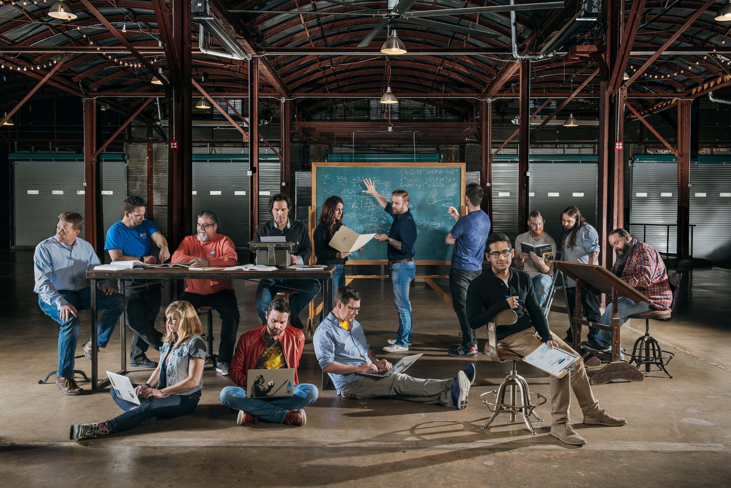 Corporate team portrait - twenty tech workers photographed in a large warehouse space.