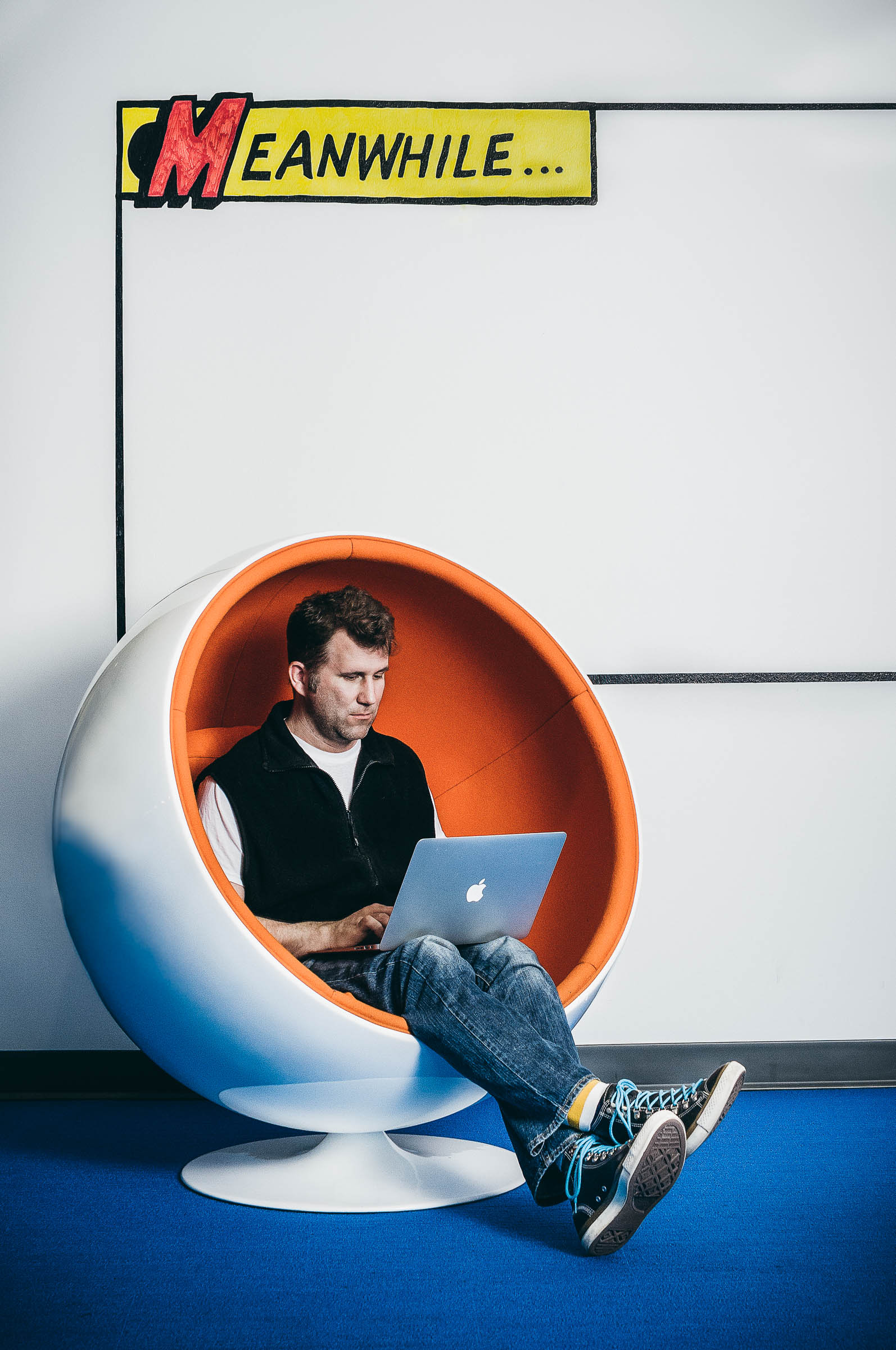 Business work culture - A man working on a laptop in a contemporary pod seat, at Indeed.com Austin Texas