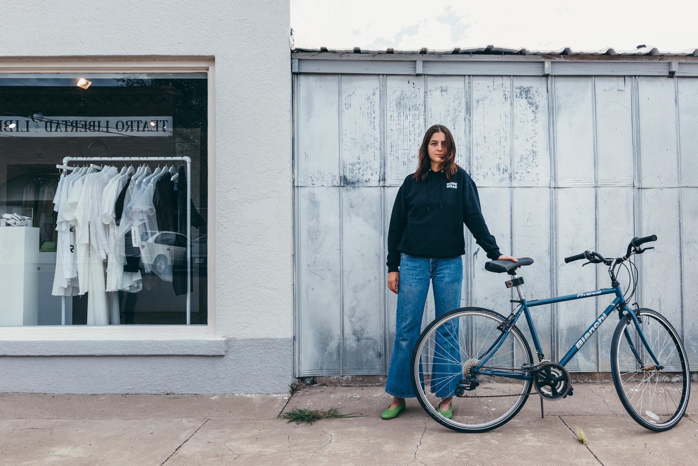 Street photography portrait - shop sales assistant with bicycle, Marfa TX