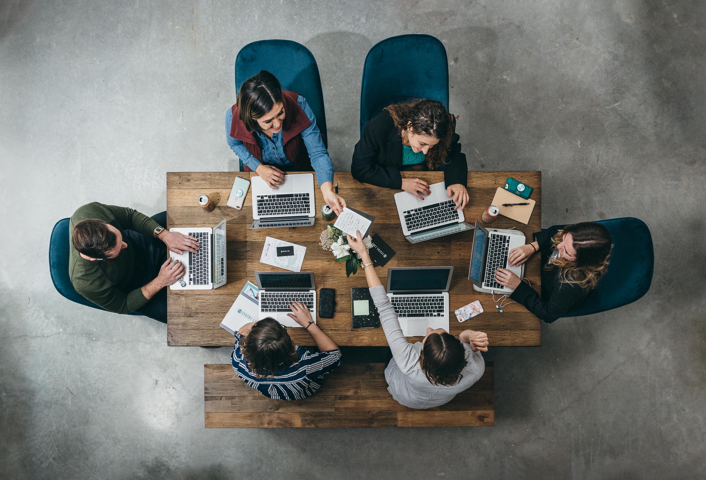 Six colleagues working on laptops photographed from above - Status Labs.