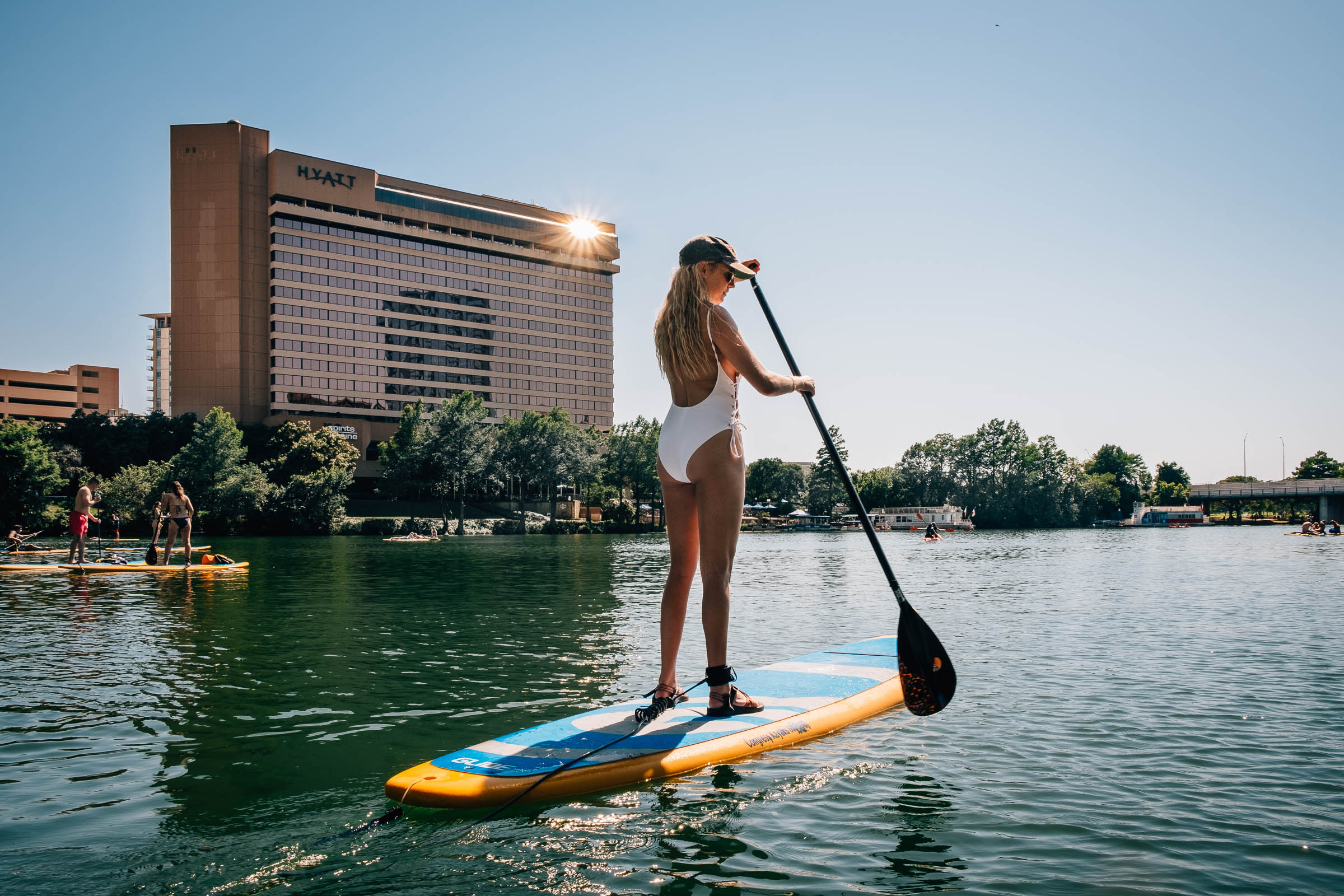 Summer travel - A paddle boarder in white bathing suit on Town Lake , Austin